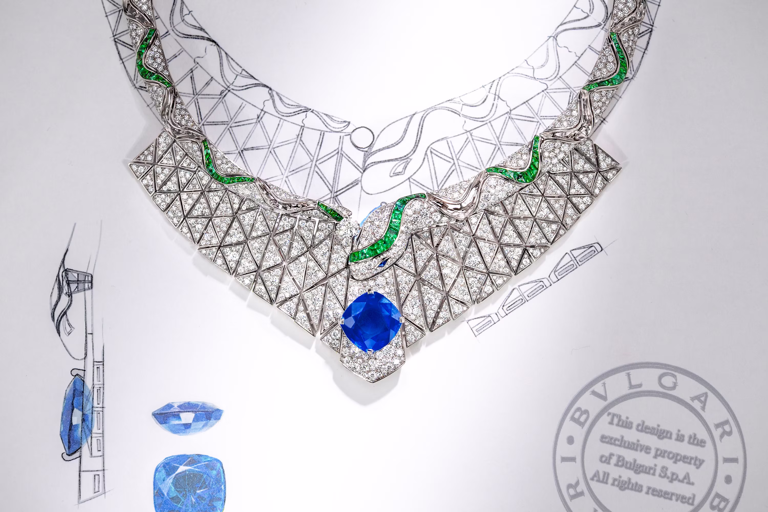 Necklace with diamonds and green details on a technical design; a large blue stone set in the center.